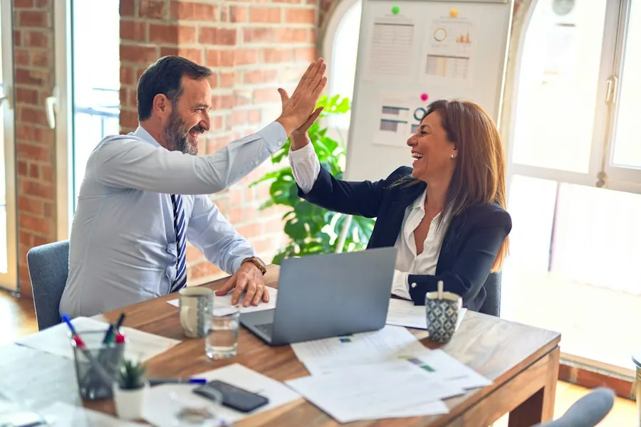 Profissionais comemorando em reunião de trabalho